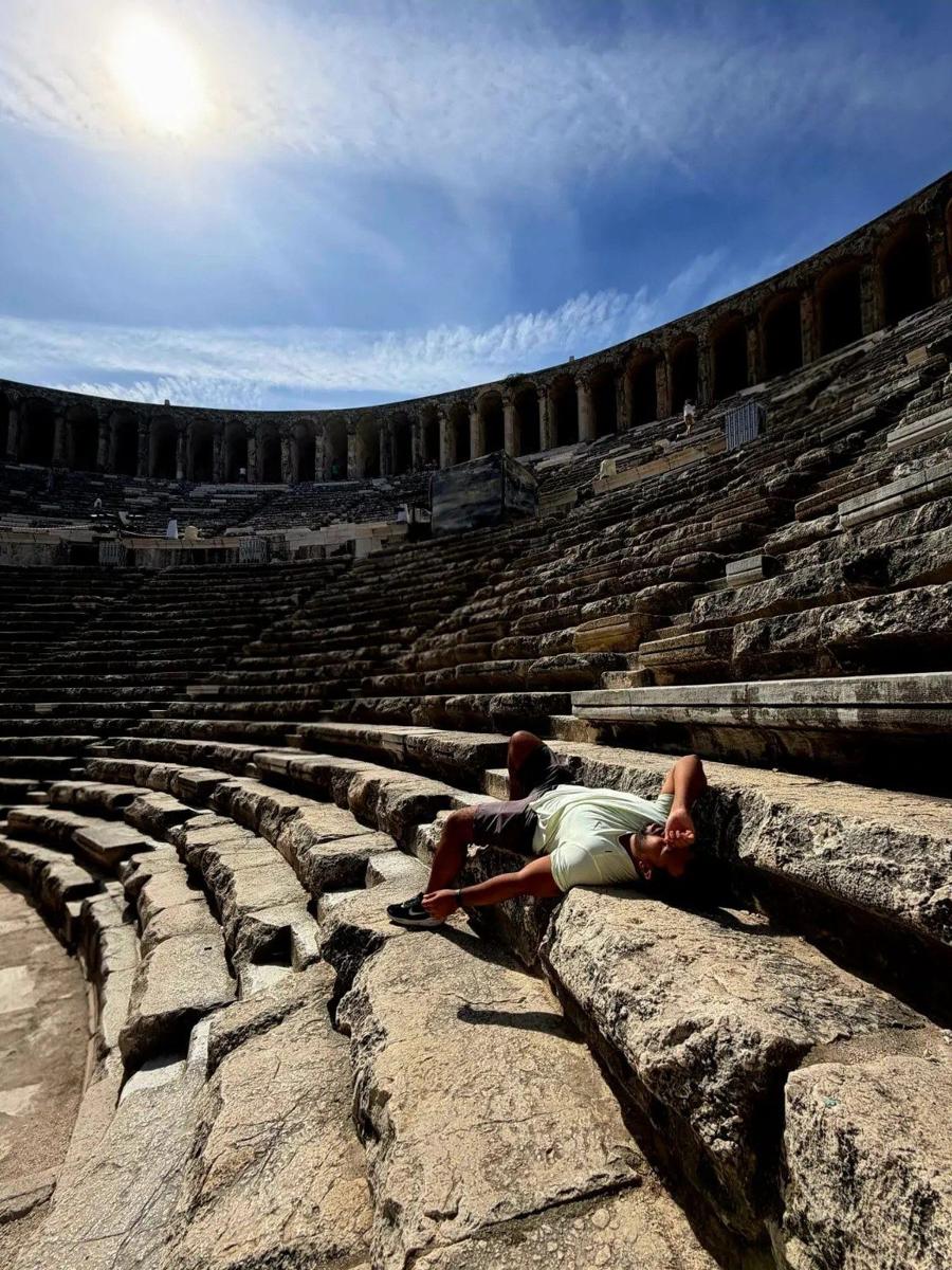 Younes allongé sur les gradins du théâtre antique d'Aspendos, en Turquie