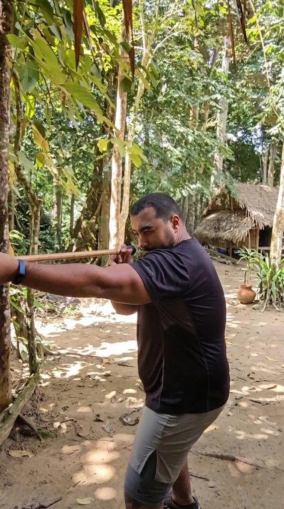Younes apprenant à tirer à la sarbacane dans la jungle de Taman Negara, Malaisie