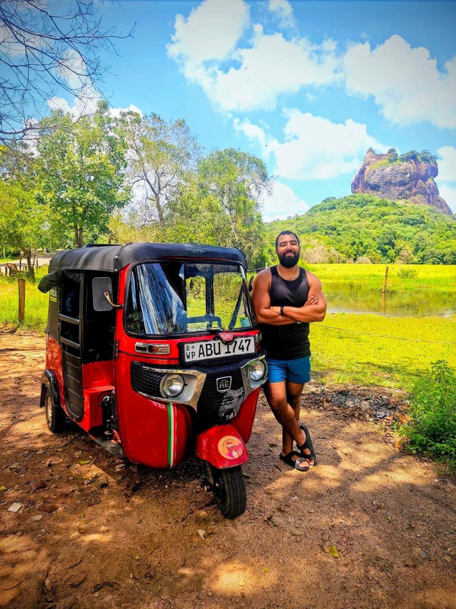Younes à côté d'un tuk-tuk rouge devant le rocher de Sigiriya, Sri Lanka
